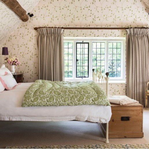 A Master bedroom in one country project by Antonia Stewart. The room was wrapped in a wallpaper that was especially coloured for this  room, taking it all the way up into the A-shaped ceiling space for the maximum effect.